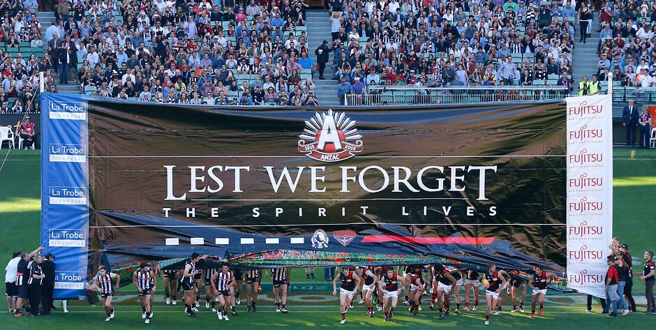AFL 2016 Rd 05 - Collingwood v Essendon MELBOURNE, AUSTRALIA - APRIL 25: Players run through a joint banner during the 2016 AFL Round 05 ANZAC Day match between the Collingwood Magpies and the Essendon Bombers at the Melbourne Cricket Ground, Melbourne on April 25, 2016. (Photo by Adam Trafford/AFL Media)